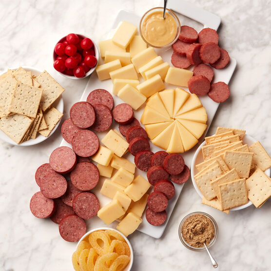 Great Taste Gift Basket meat and cheeses sliced and placed on board with crackers, mustard, and candy