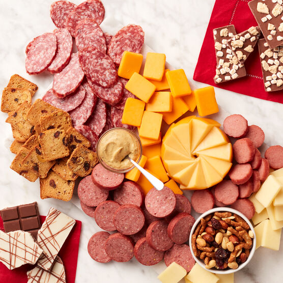 Premium Charcuterie & Chocolate Gift Box meat and cheese sliced and arranged on board with mustard, chocolates, and nuts