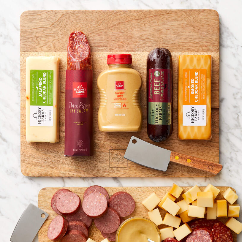 Signature Bites and Board Gift Set includes beef sausage, dry salami, mustard, various cheese, and a cutting board